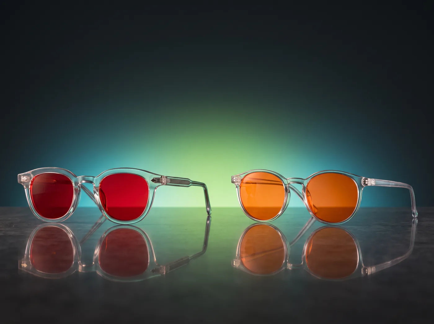 Lentes Sleep Mode de Insae, de armazón transparente y mica roja, junto a unos lentes de mica naranja sin marca